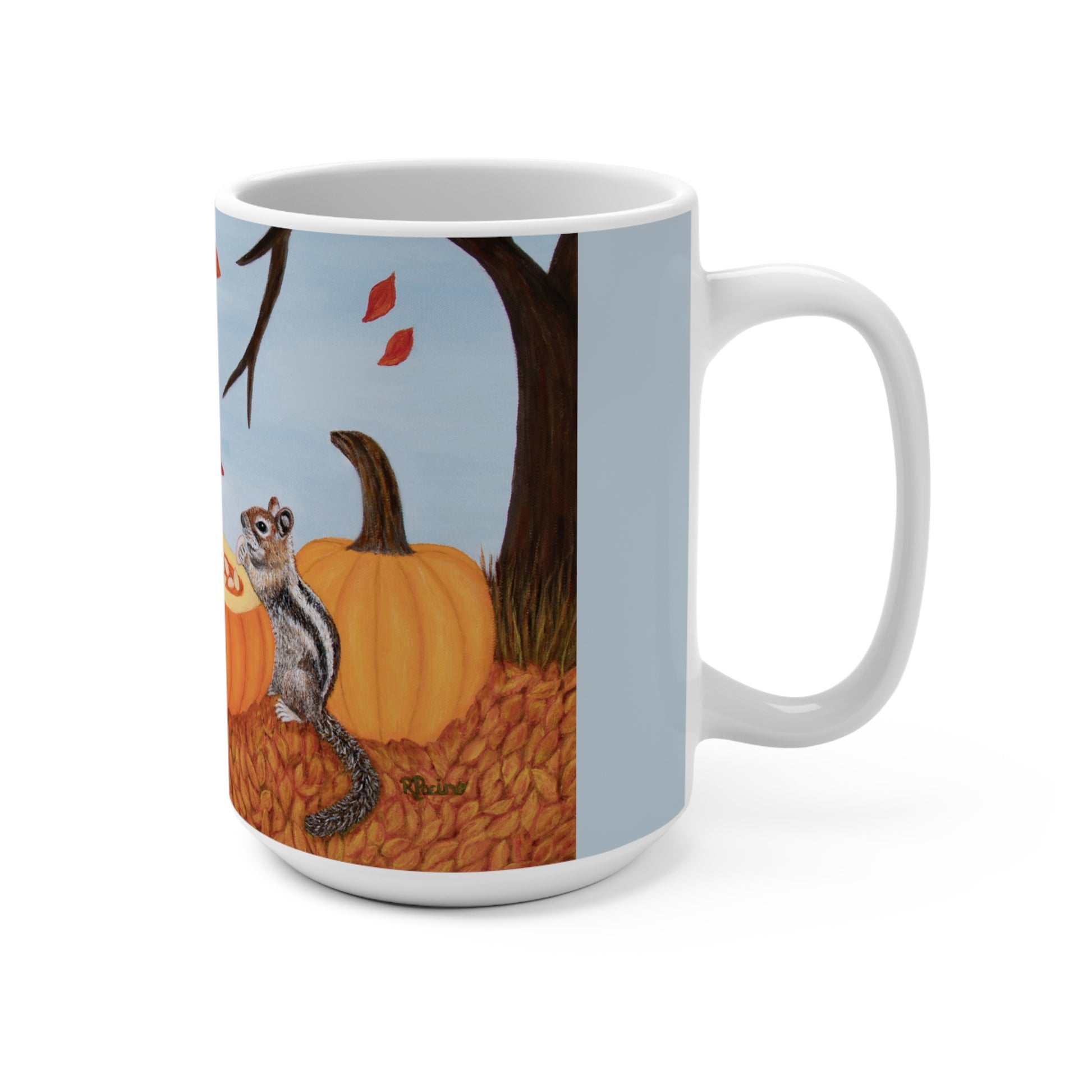 A white ceramic mug featuring a printed autumn illustration of a squirrel next to a large orange pumpkin, with a tree trunk and light blue sky in the background.