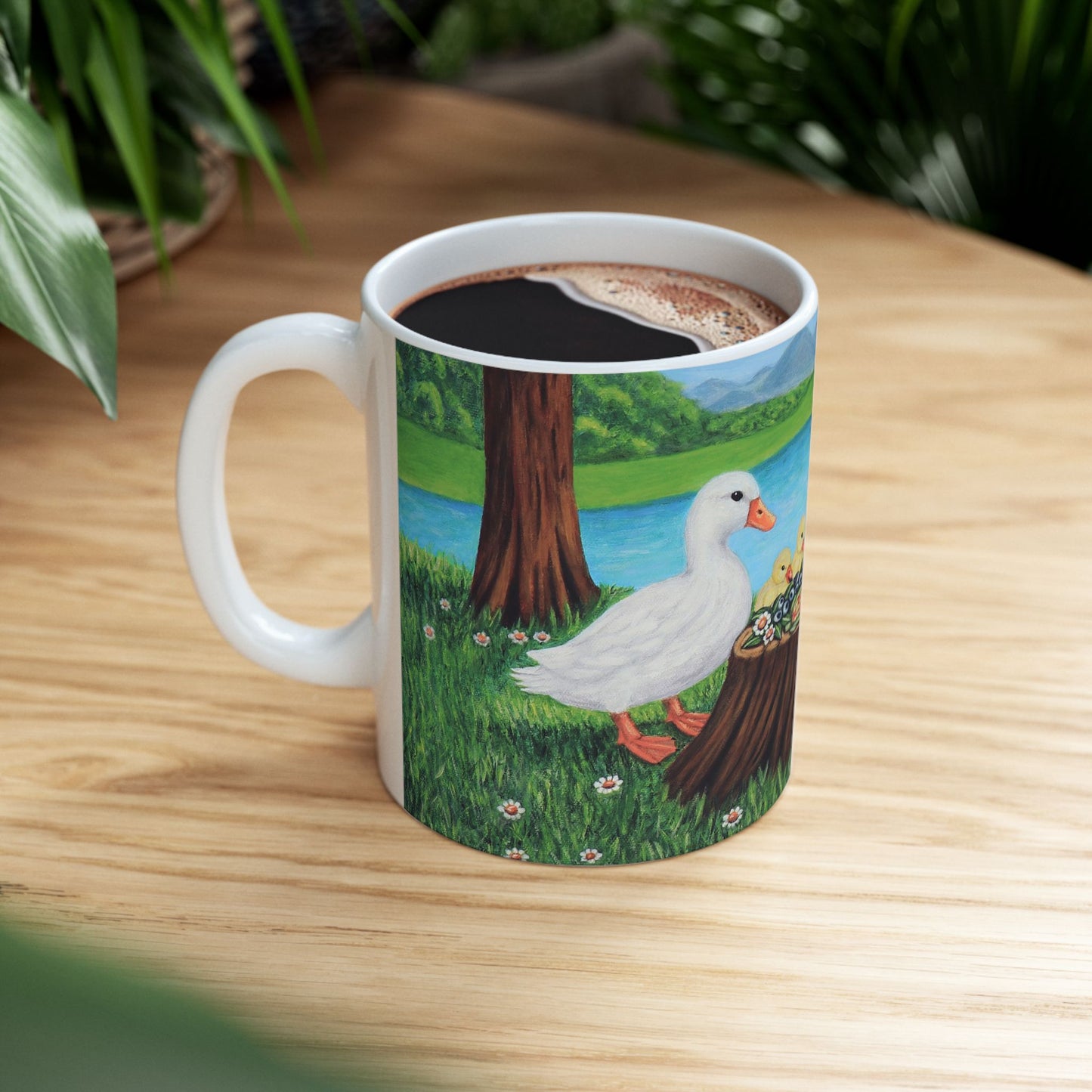 11 oz white ceramic mug featuring Sunlit Supper by Roberta Pacino with two white ducks and three ducklings gathered around a tree stump near the water