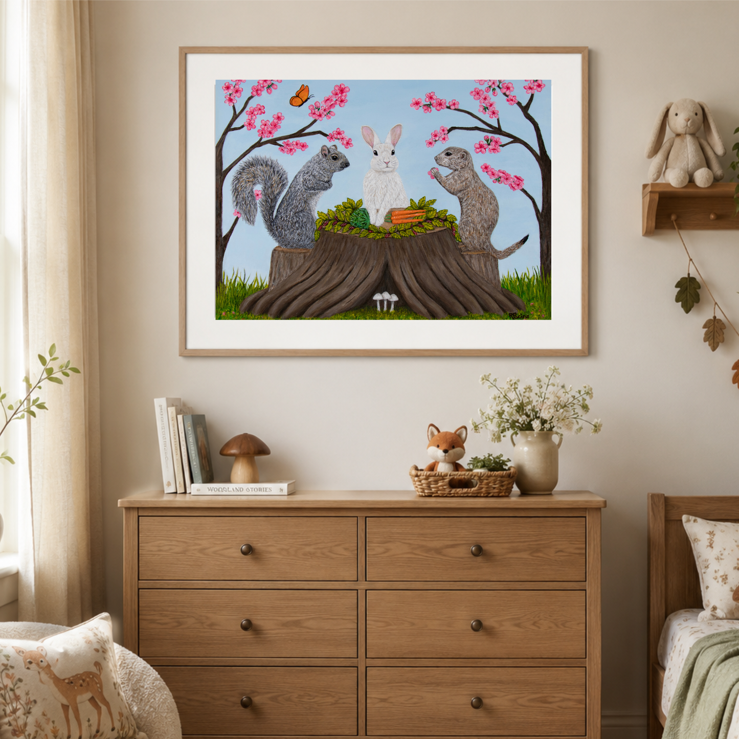 Garden Gathering museum print displayed in a natural wood frame above a dresser in a woodland-inspired child’s room