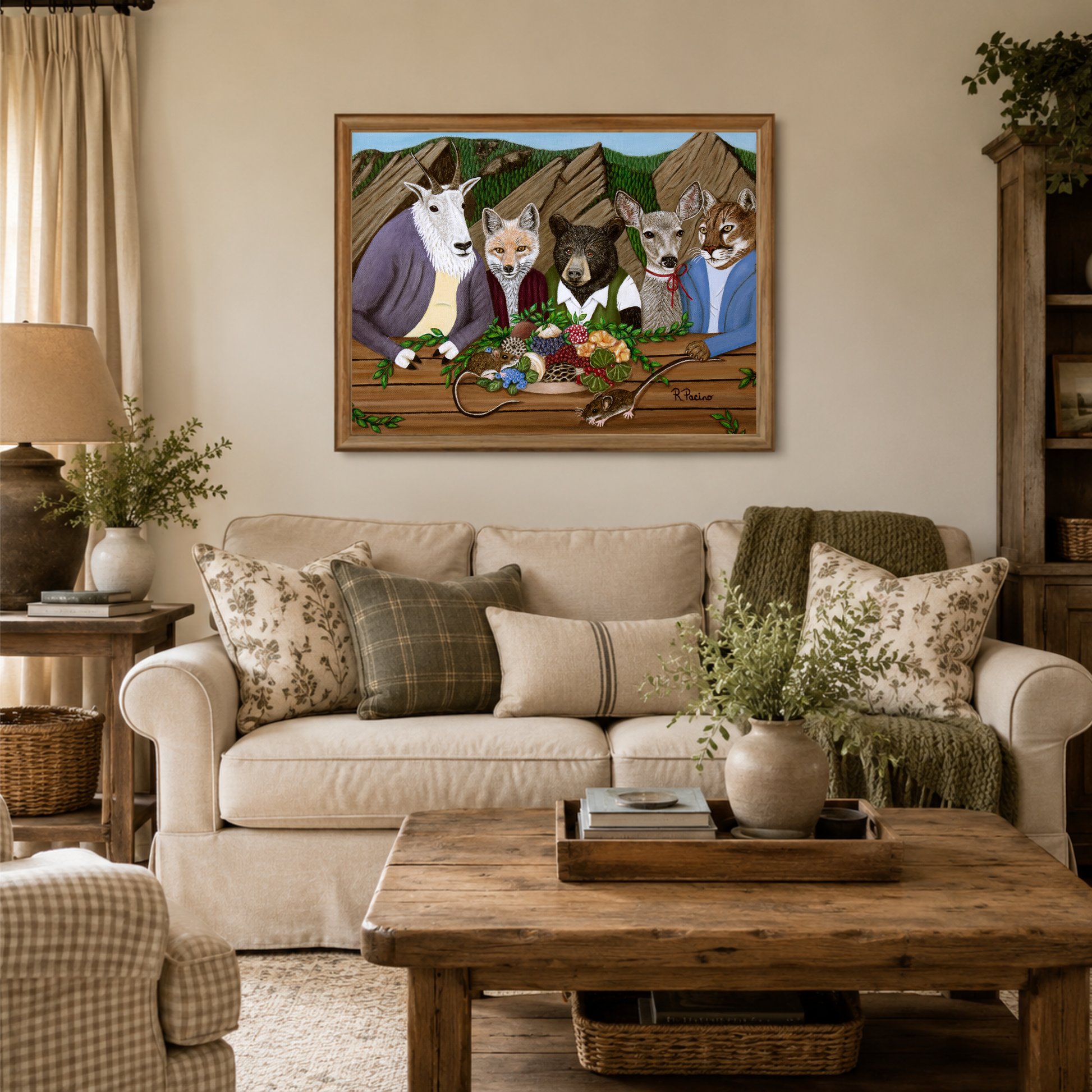 A framed art print depicting anthropomorphic wildlife at a picnic hanging on a beige wall above a cream sofa in a styled living room.